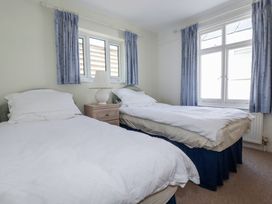 A bedroom with two single beds and a nightstand with a lamp at Kiln Cottage in Golant near Tywardreath