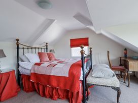 A bedroom with a bed and a table at Kiln Cottage in Golant near Tywardreath