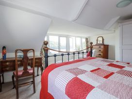 A bedroom with a bed and a desk at Kiln Cottage in Golant near Tywardreath