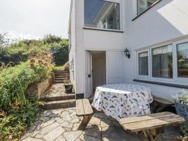 An outdoor area with a table and benches at Kiln Cottage in Golant near Tywardreath