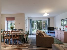 A living room with a dining area and windows at Manorcombe 21 Honicombe Holiday Village near Gunnislake
