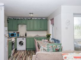 A kitchen with appliances and dining table at Manorcombe 21 Honicombe Holiday Village near Gunnislake