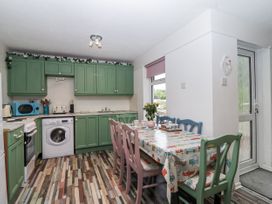 A kitchen with green cabinets and a dining table at Manorcombe 21 near Honicombe Holiday Village
