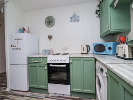 A kitchen with appliances including a refrigerator, oven and microwave at Manorcombe 21 in Honicombe Holiday Village near Gunnislake