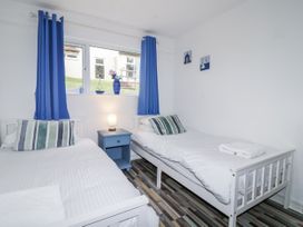 A bedroom with two beds and a bedside table at Manorcombe 21 Honicombe Holiday Village near Gunnislake