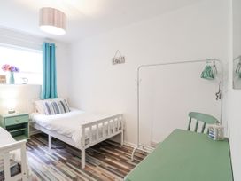 A bedroom with two beds, a desk, and a lamp at Manorcombe 21 Honicombe Holiday Village near Gunnislake