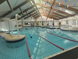 An indoor swimming pool with diving board and spa area at Manorcombe 21 Honicombe Holiday Village near Gunnislake