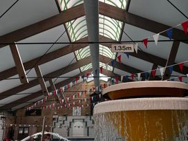 An indoor pool area with a fountain and bunting at Manorcombe 21 Honicombe Holiday Village near Gunnislake