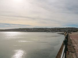 A seaside view with a pathway and calm water at Mill House Barn