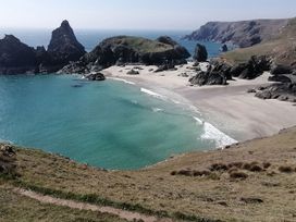 A beach with rock formations and blue water at Mill House Barn