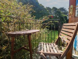 A balcony with a table and chair at Mill House Barn Gulval near Penzance