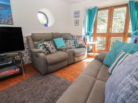 A living room with sofas and a television at Mill House Barn in Gulval near Penzance