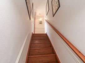 A staircase leading up with framed pictures on the wall at Mill House Barn in Gulval near Penzance