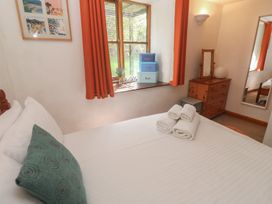 A bedroom with a bed and a dresser at Mill House Barn in Gulval near Penzance