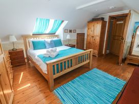 A bedroom with a bed and wardrobe at Mill House Barn Gulval near Penzance