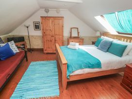 A bedroom with a bed and sofa bed at Mill House Barn in Gulval near Penzance