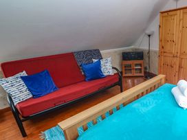 A bedroom with a sofa bed and storage cabinet at Mill House Barn Gulval near Penzance