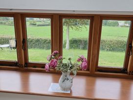 A window with a vase of flowers next to a table at The Dairy in 