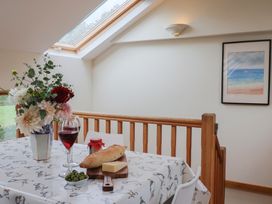 A dining room with a table set with bread, cheese, wine, and flowers at The Dairy in 
