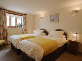 A bedroom with two beds and a window at The Dairy 