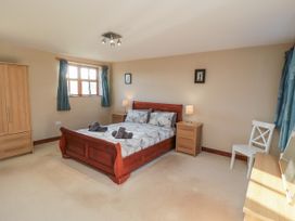 A bedroom with a bed and furniture at Pasture View Sneatonthorpe near Whitby