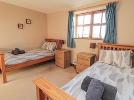 A bedroom with two single beds and bedside tables at Pasture View Sneatonthorpe near Whitby