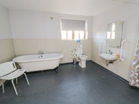A bathroom with a bathtub, toilet, and sink at Pasture View Sneatonthorpe near Whitby