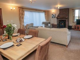 A living room with a dining table and a fireplace at Pasture View in Sneatonthorpe near Whitby