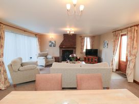 A living room with a sofa, armchairs, and a television at Pasture View in Sneatonthorpe near Whitby