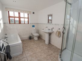 A bathroom with a bath tub, toilet, sink, and shower at Beck View in Whitby