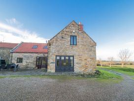 A building with stone exterior and windows at Wheelhouse Cottage in 