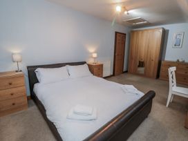 A bedroom with a bed and wooden furniture at Wheelhouse Cottage Sneatonthorpe near Whitby