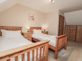 A bedroom with two beds and a chest of drawers at Wheelhouse Cottage Sneatonthorpe near Whitby