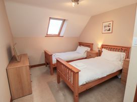 A bedroom with two beds and a dresser at Wheelhouse Cottage Sneatonthorpe near Whitby