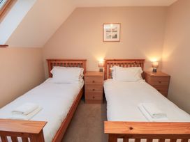 A bedroom with two single beds and bedside tables at Wheelhouse Cottage Sneatonthorpe near Whitby