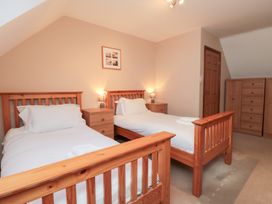A bedroom with two single beds and a wardrobe at Wheelhouse Cottage Sneatonthorpe near Whitby
