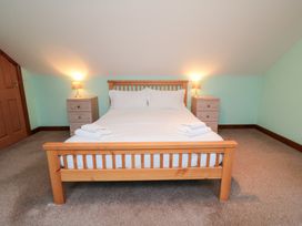 A bedroom with a bed and bedside tables at Wheelhouse Cottage in Sneatonthorpe near Whitby