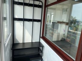 A hallway with a coat rack and bench at Hafod Y Graig in Morfa Bychan