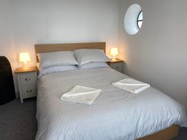 A bedroom with a bed and nightstand at Hafod Y Graig Morfa Bychan