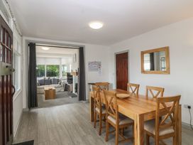 A dining room with a wooden table and chairs at Seaview Hafod Y Graig in Morfa Bychan