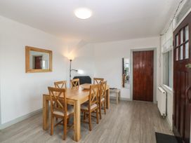 A dining room with a table and chairs at Seaview Hafod Y Graig in Morfa Bychan