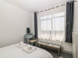 A bedroom with a bed and a mirror at Seaview Hafod Y Graig Morfa Bychan