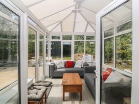 A conservatory with a sofa and coffee table at Seaview Hafod Y Graig in Morfa Bychan