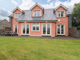 A house with a pink exterior and patio area at 25 Ring of Kerry Holiday Cottages in Kenmare