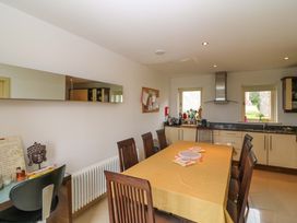A kitchen with a dining table and chairs at 25 Ring of Kerry Holiday Cottages in Kenmare