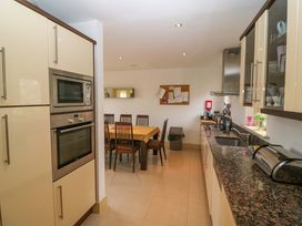 A kitchen with appliances and a dining table at 25 Ring of Kerry Holiday Cottages Kenmare