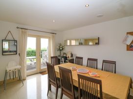 A dining room with a long table and chairs at 25 Ring of Kerry Holiday Cottages Kenmare