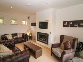 A living room with a sofa and armchair at 25 Ring of Kerry Holiday Cottages in Kenmare