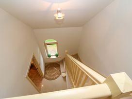 A staircase with a window and a rug at 25 Ring of Kerry Holiday Cottages in Kenmare