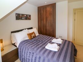A bedroom with a bed and wardrobe at 25 Ring of Kerry Holiday Cottages in Kenmare
